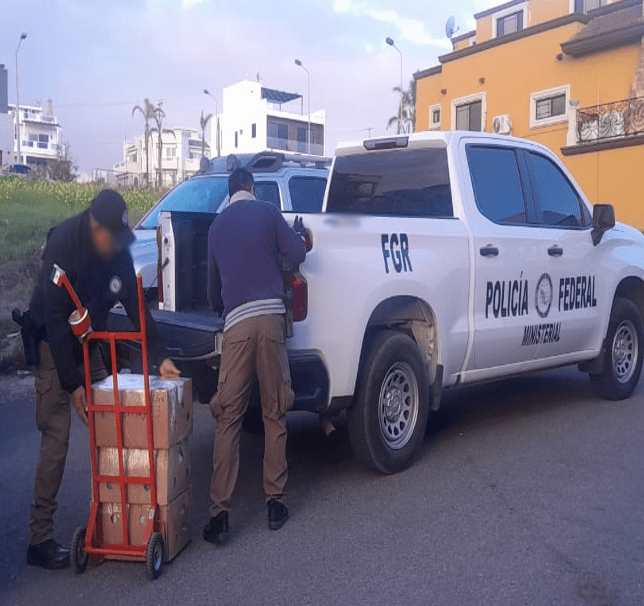 Police officers unloading boxes from truck.