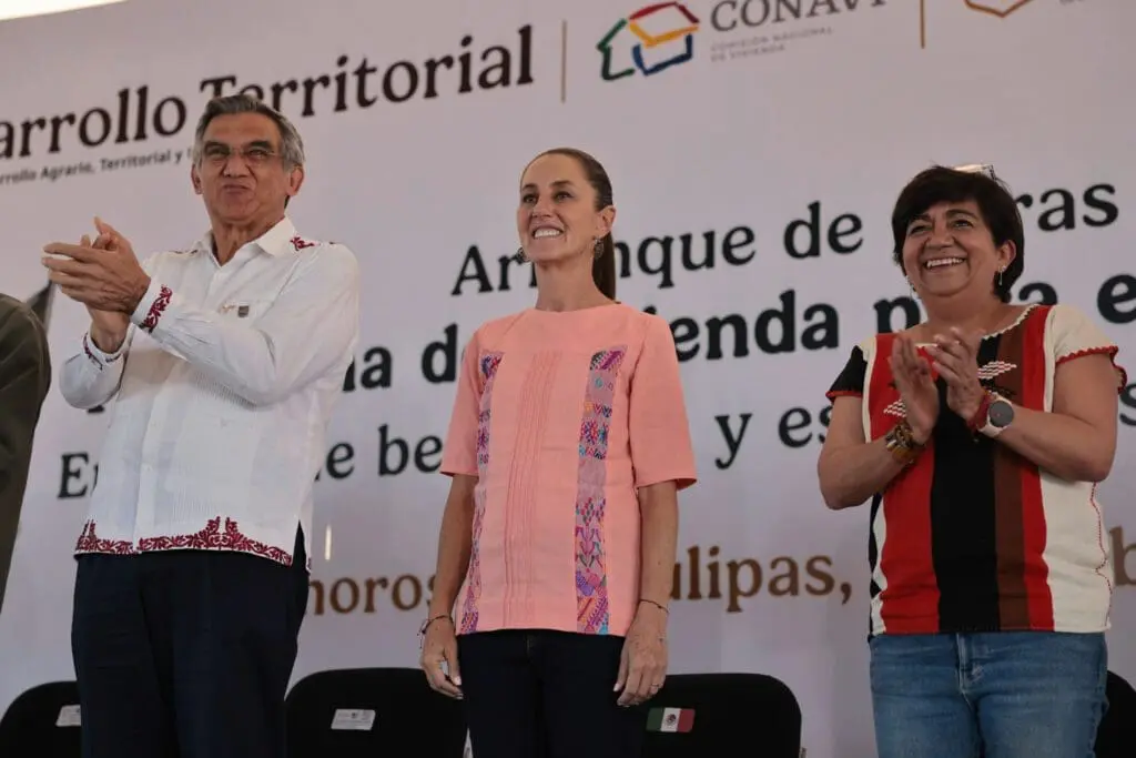 Three people standing and clapping at event.