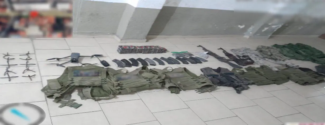 Military gear and equipment displayed on floor.