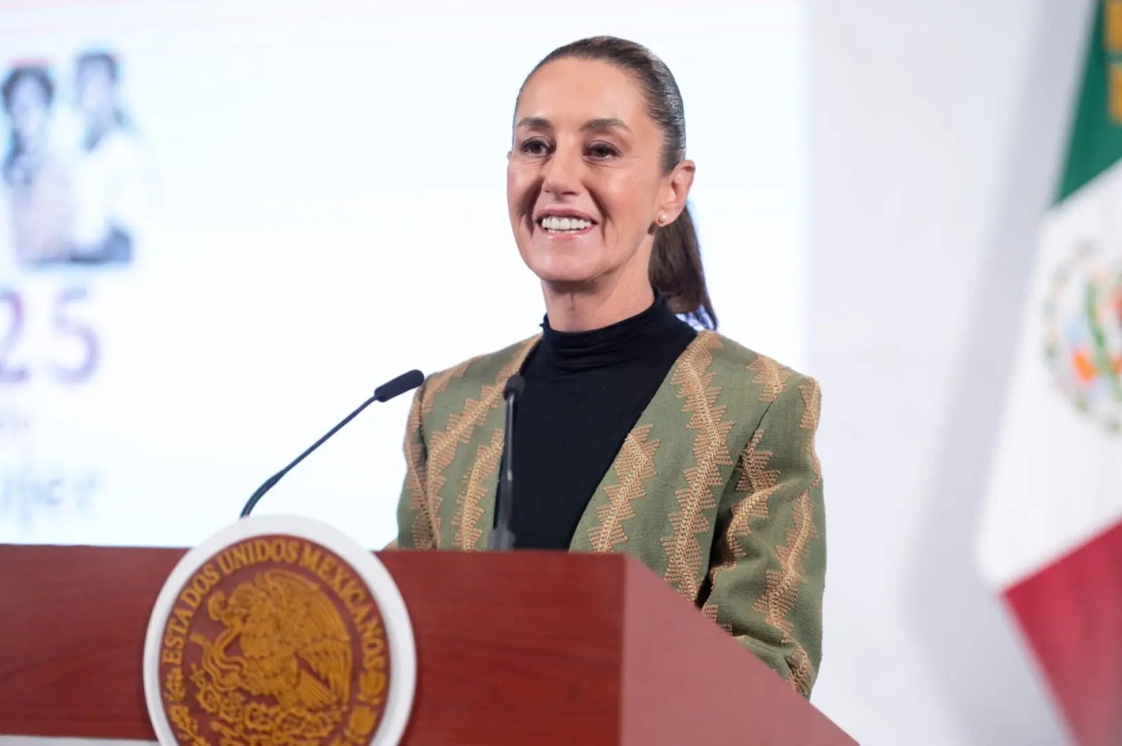 Person speaking at a podium, Mexico emblem.