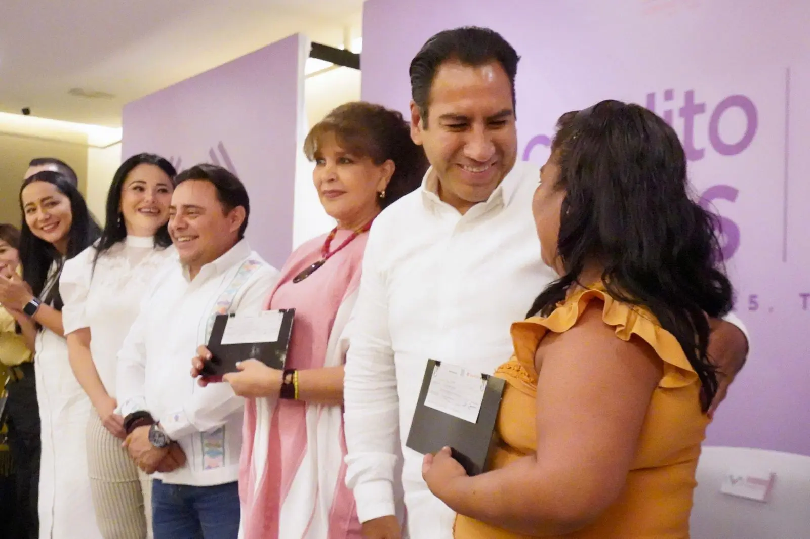 People smiling and holding awards on stage.