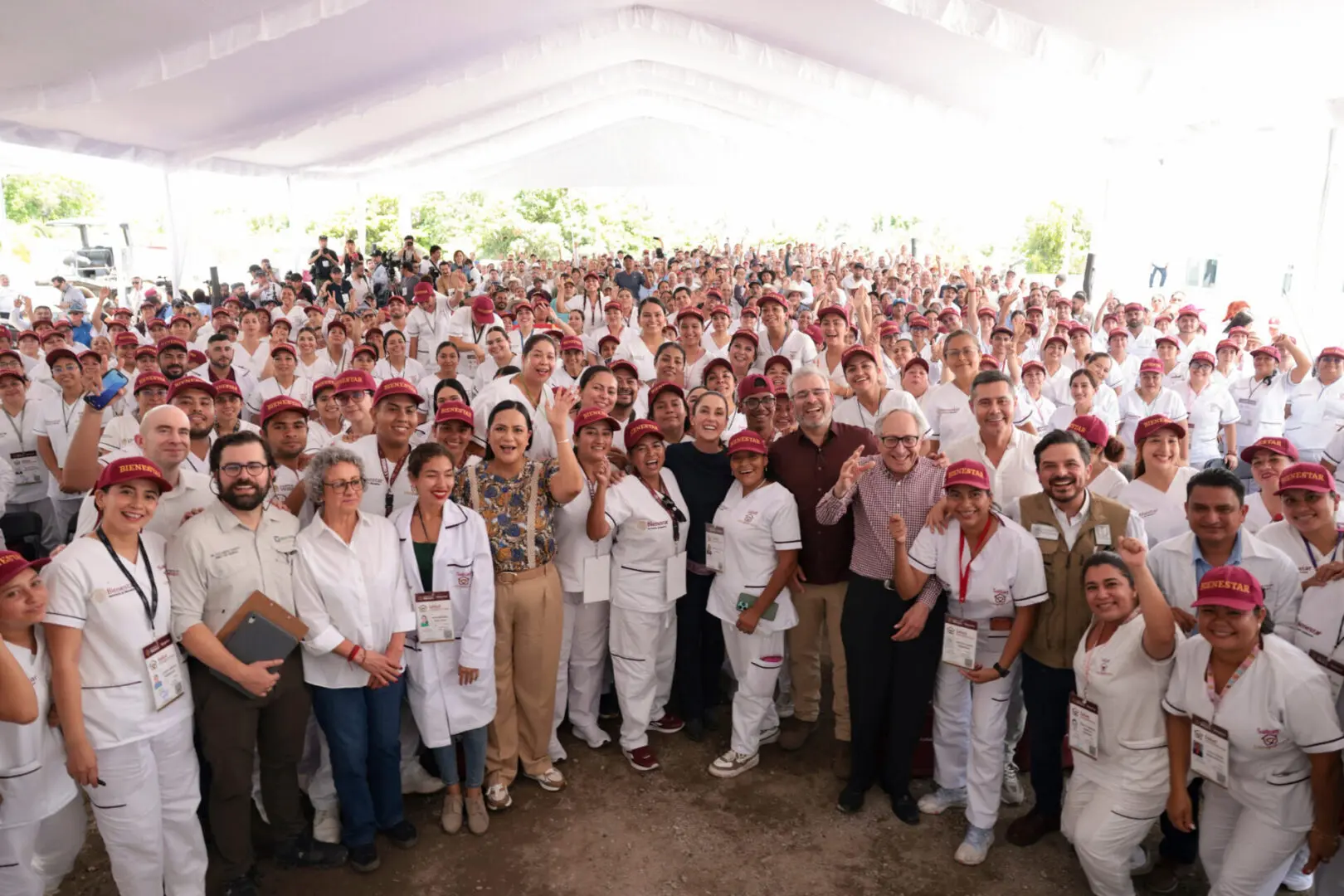 Large group of people gathered under tent.