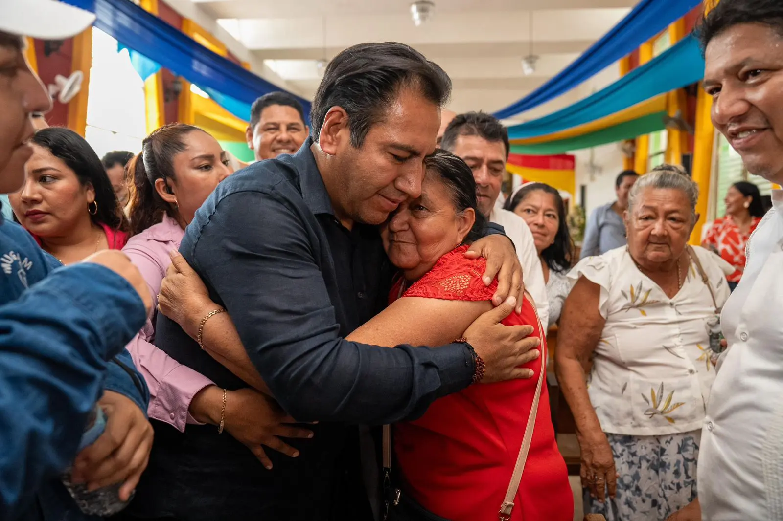 People hugging at a public gathering event.
