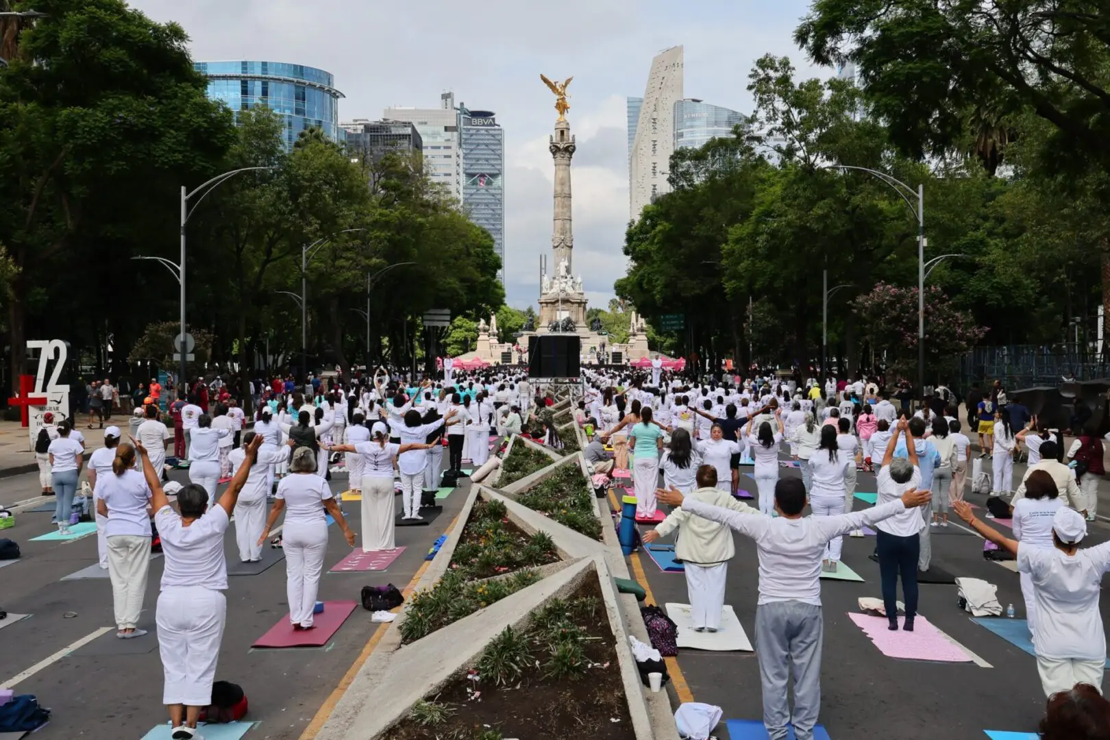 People practicing yoga on city street.