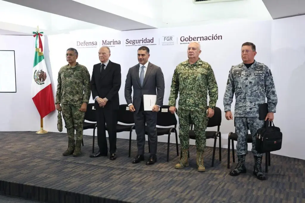 Five officials standing in front of flags.
