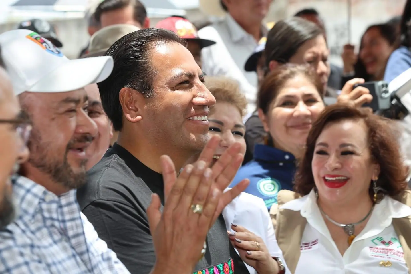 group of smiling people applauding at event