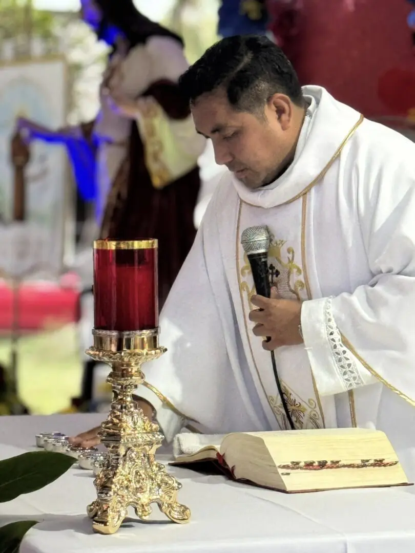 Priest conducting a religious ceremony with microphone.