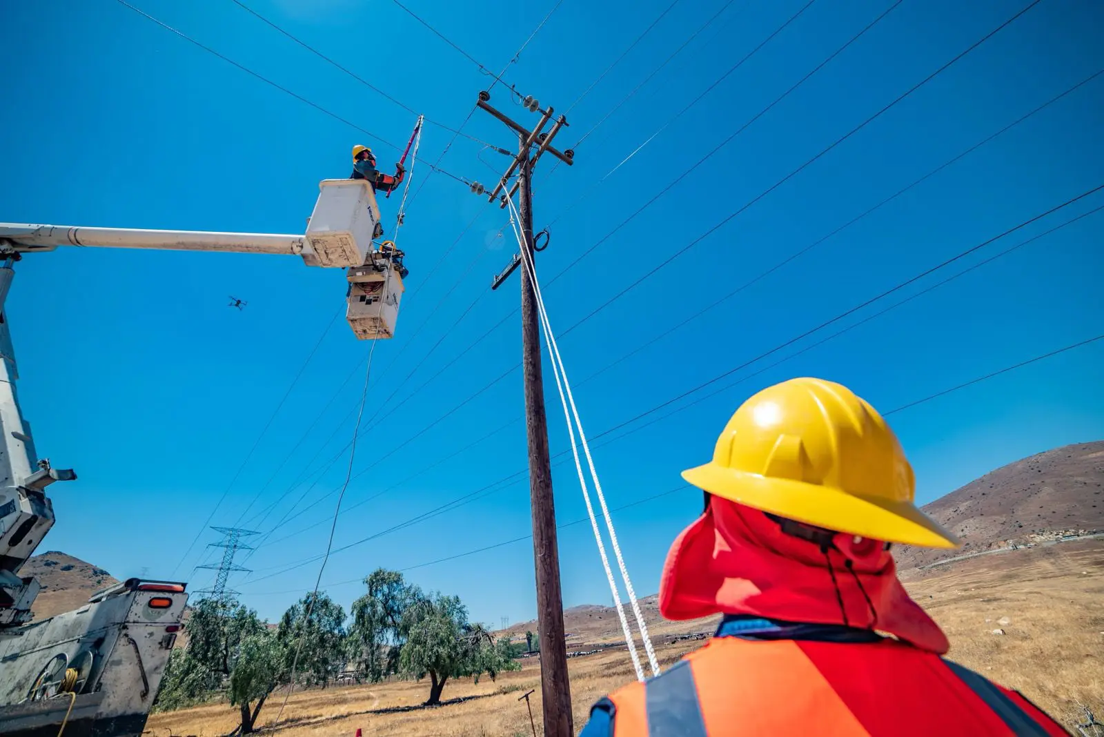 Trabajadores de la CFE realizan mantenimiento en líneas eléctricas.