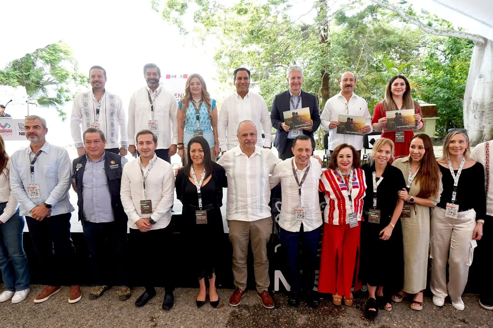 Group of people smiling outdoors at event.