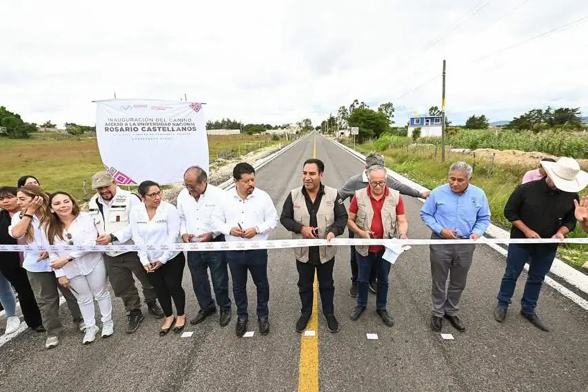 People at ribbon-cutting ceremony on road.