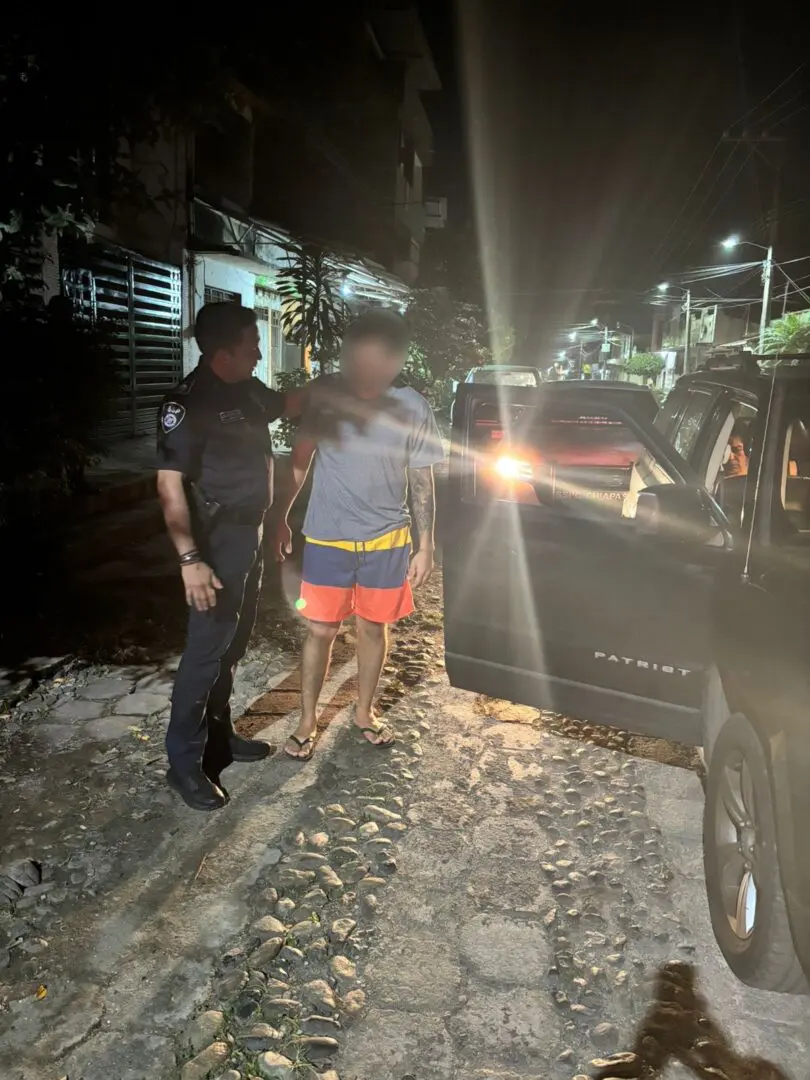 Police officer interacting with a man at night.