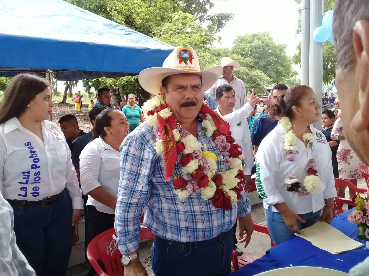 Jesús Orantes Ruiz durante un evento público, con sombrero y guirnaldas de flores, acompañado de simpatizantes en Chiapas.