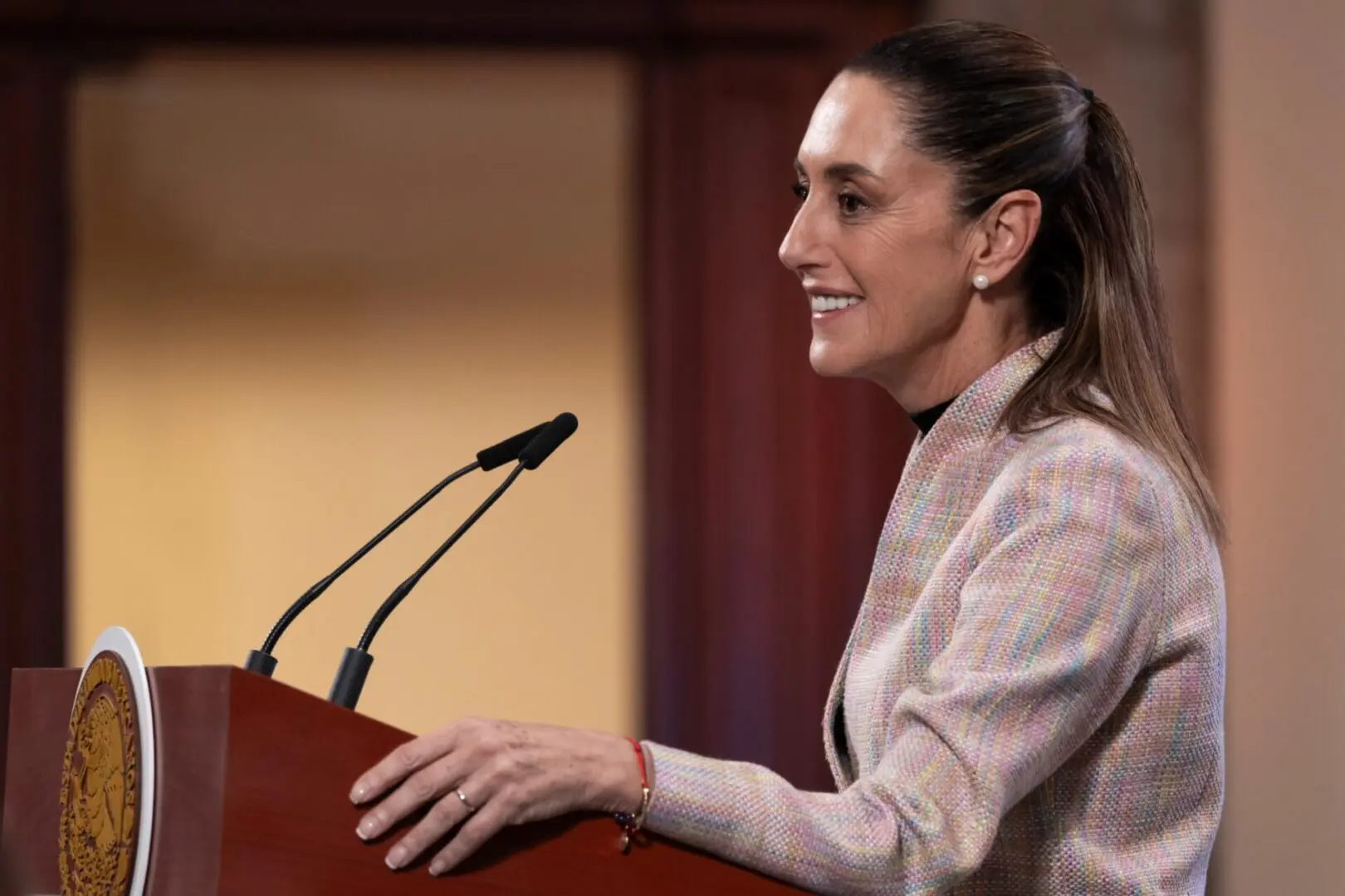 Smiling woman speaking at wooden podium