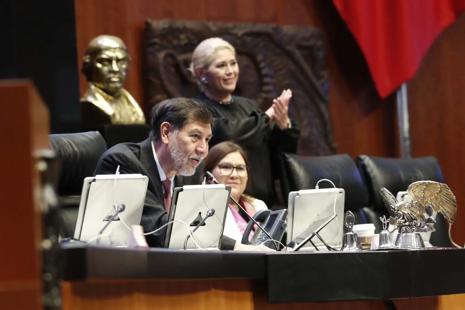 Politicians at conference table with microphones.
