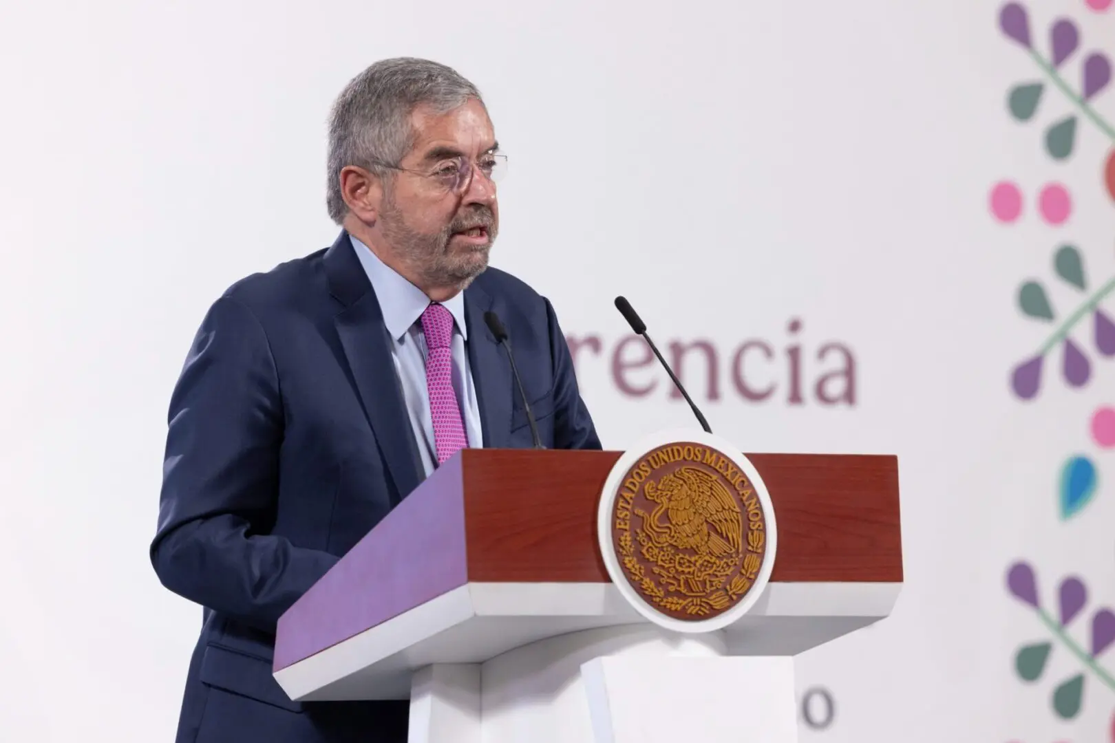 Man speaking at a podium during conference.
