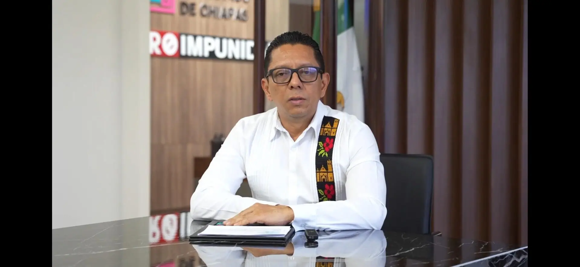 Man sitting at desk with notebook.