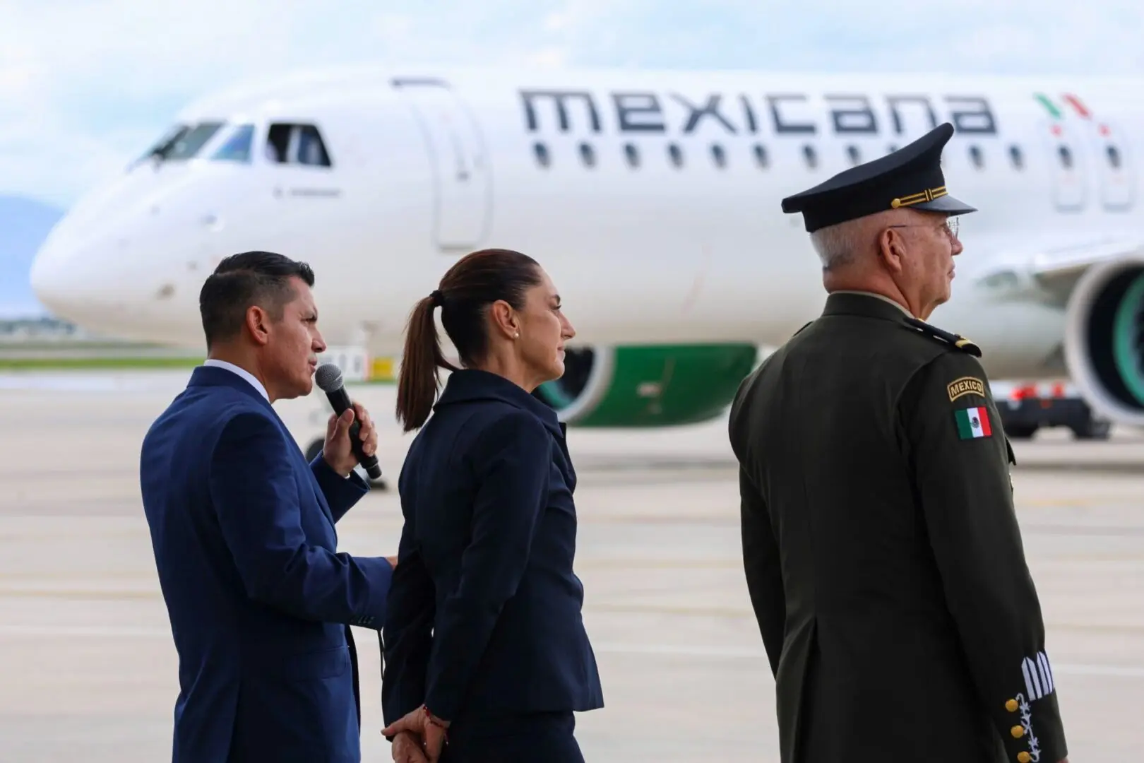 People standing near Mexicana airplane on runway.