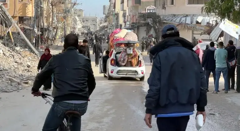Personas desplazadas en Gaza caminan entre escombros y vehículos improvisados