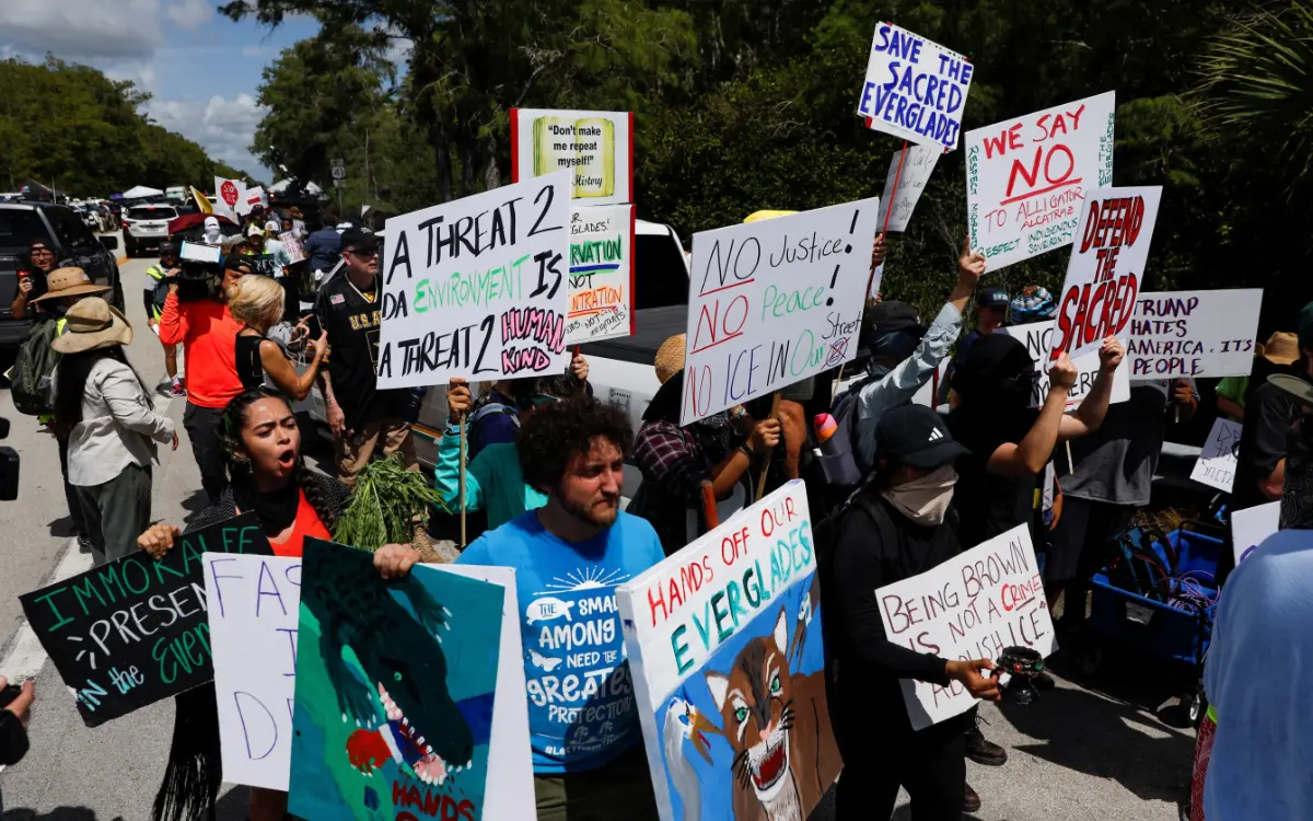 Protesters holding signs at environmental demonstration.