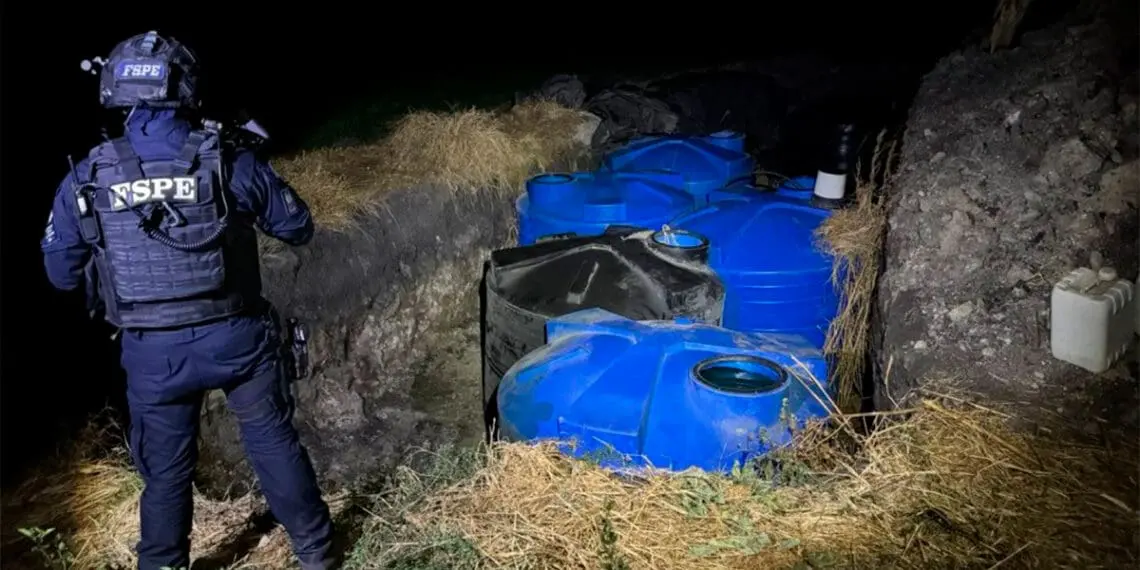 Tactical officer inspecting blue storage tanks