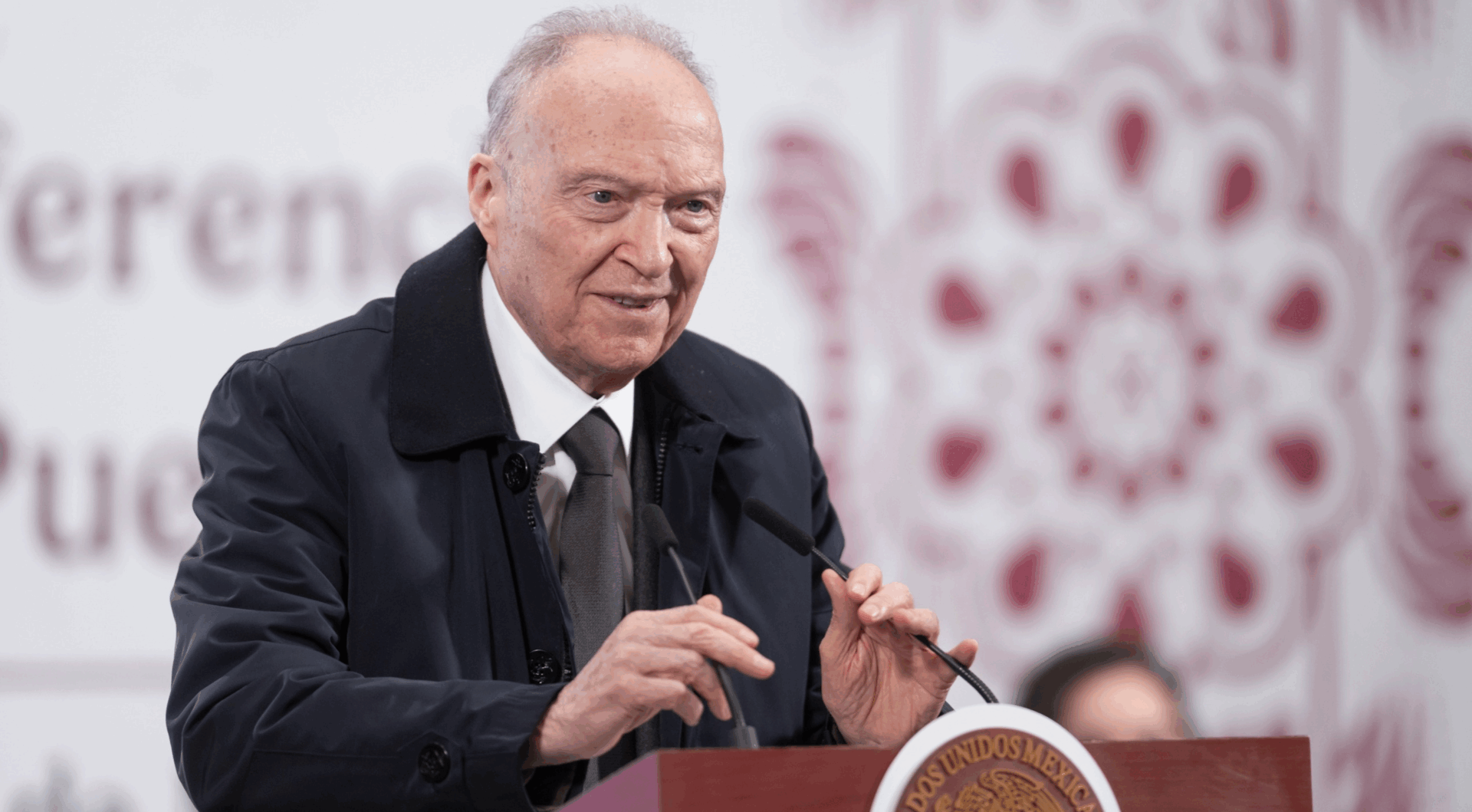 Older man speaking at podium with glasses