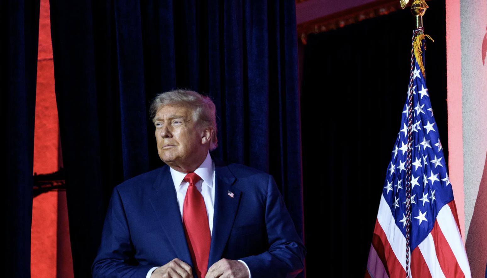 Donald Trump en un evento oficial junto a la bandera de Estados Unidos y el sello presidencial.