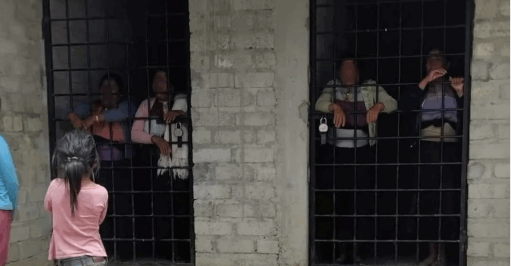Mujer tzotzil con bebé tras los barrotes en cárcel comunitaria de Chamula