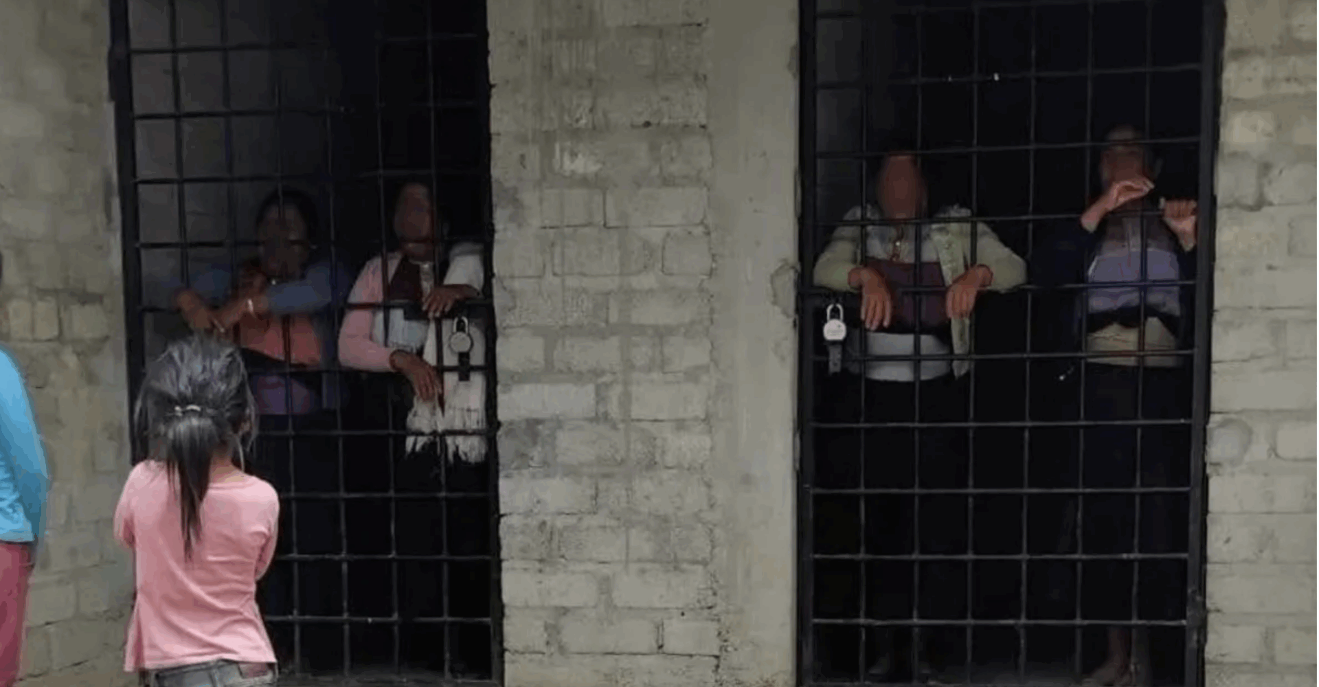 Mujer tzotzil con bebé tras los barrotes en cárcel comunitaria de Chamula