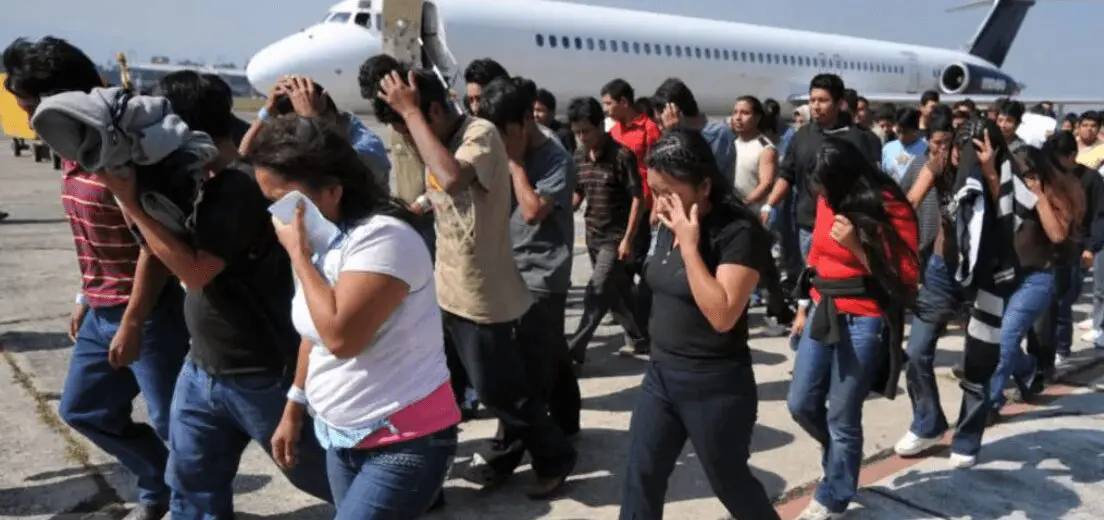 Mexicanos deportados caminan tras bajar de avión en aeropuerto