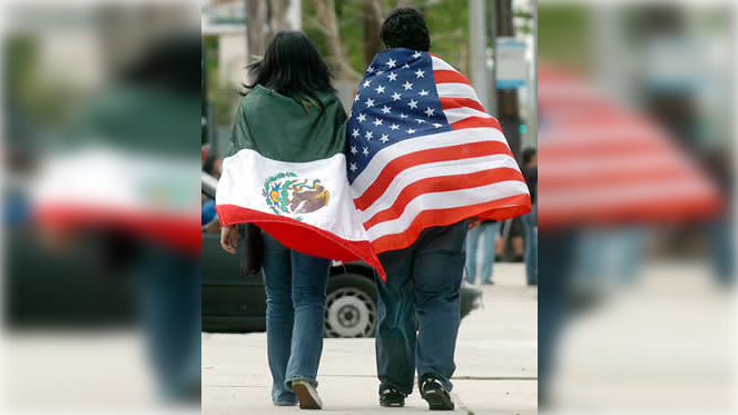 Persona sosteniendo banderas de México y Estados Unidos simbolizando la migración y pobreza