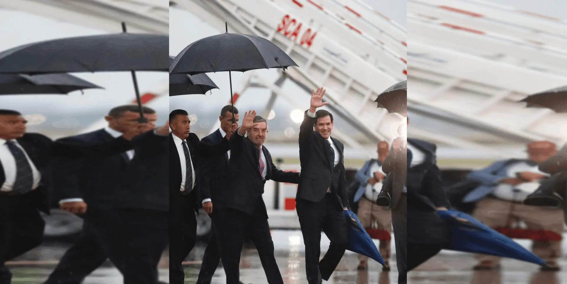 People walking under umbrellas at the airport.