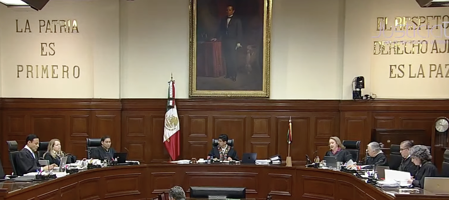 Courtroom with judges and a large portrait.