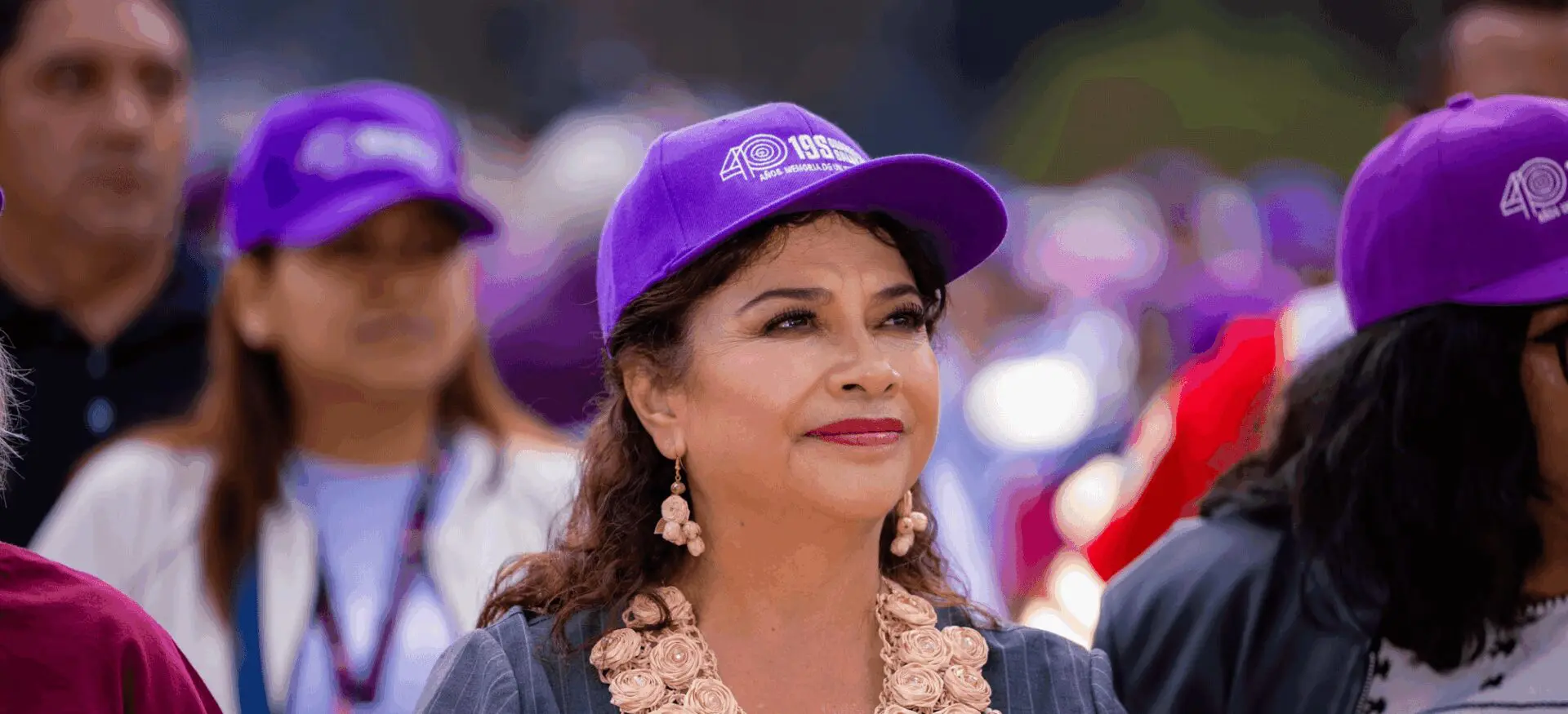Woman wearing purple cap at outdoor event.