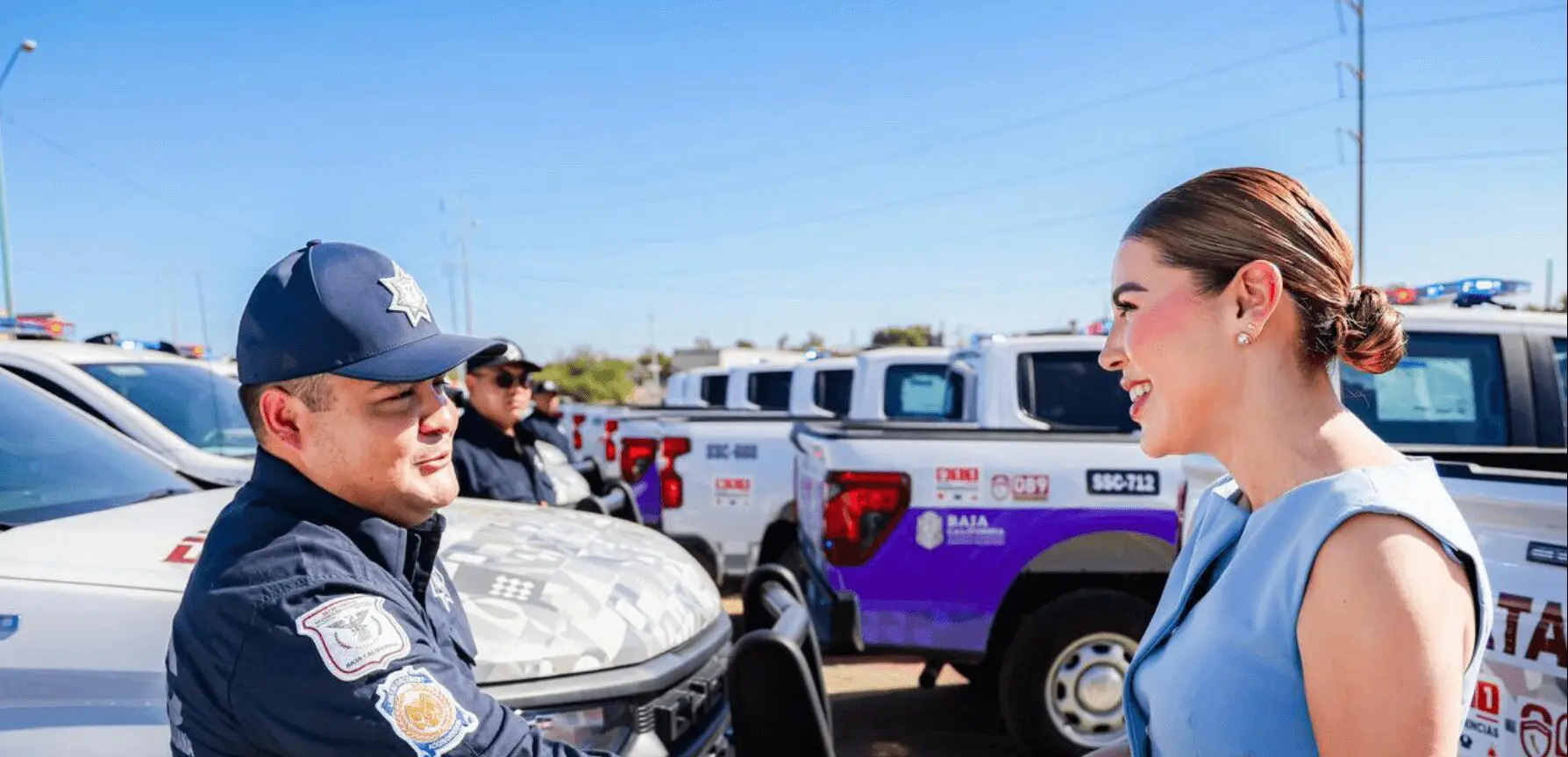Police officer and woman shake hands outdoors.