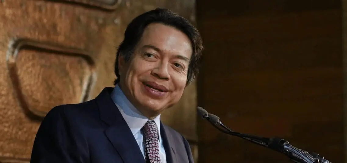 Smiling man in suit speaking at podium