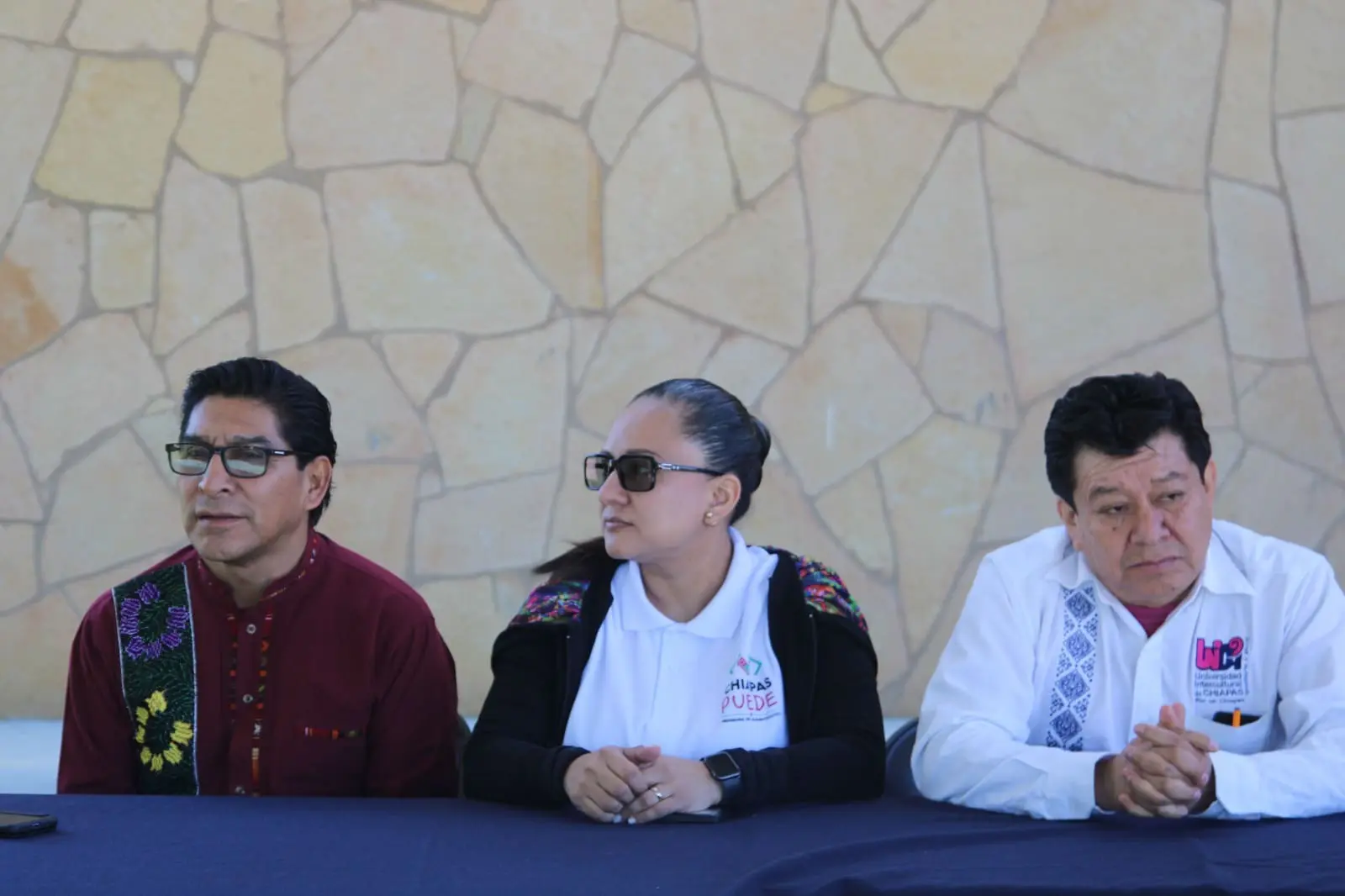 Three people sitting at a table.
