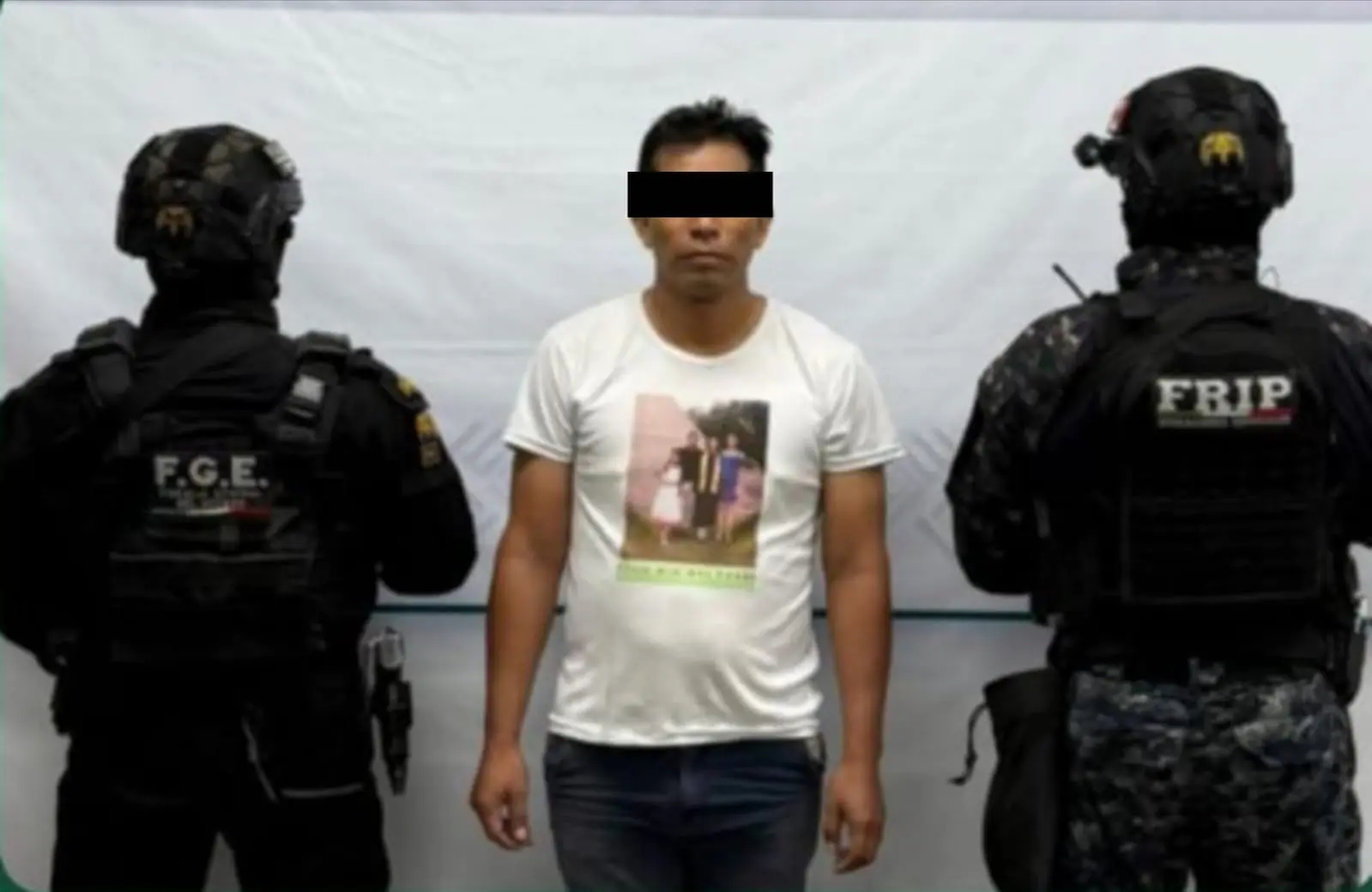 Three men, one detained by police officers.