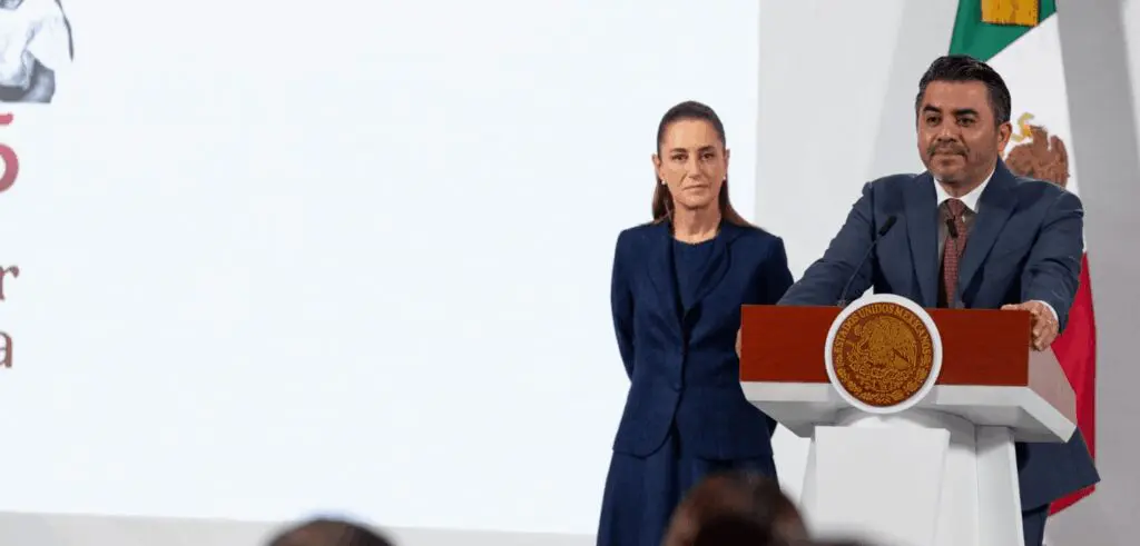 Two speakers at podium with Mexican flag
