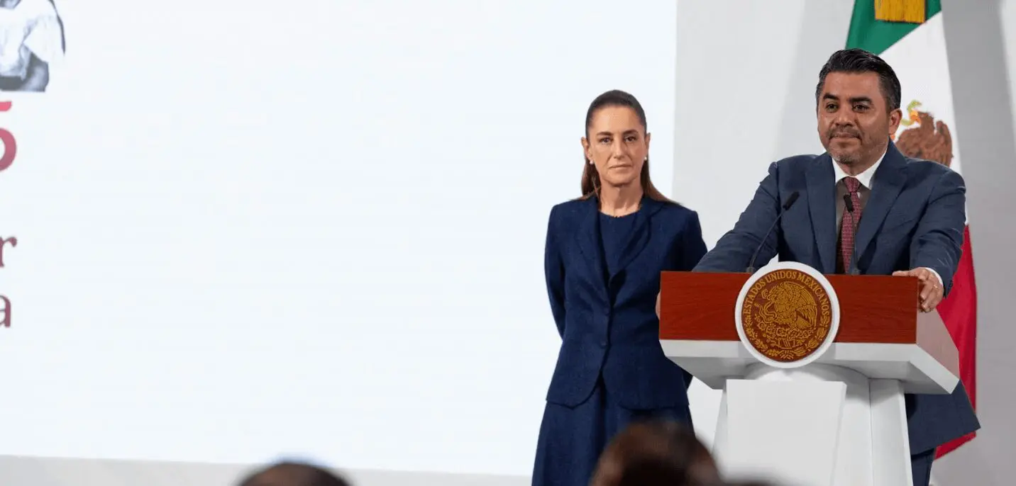 Two speakers at podium with Mexican flag