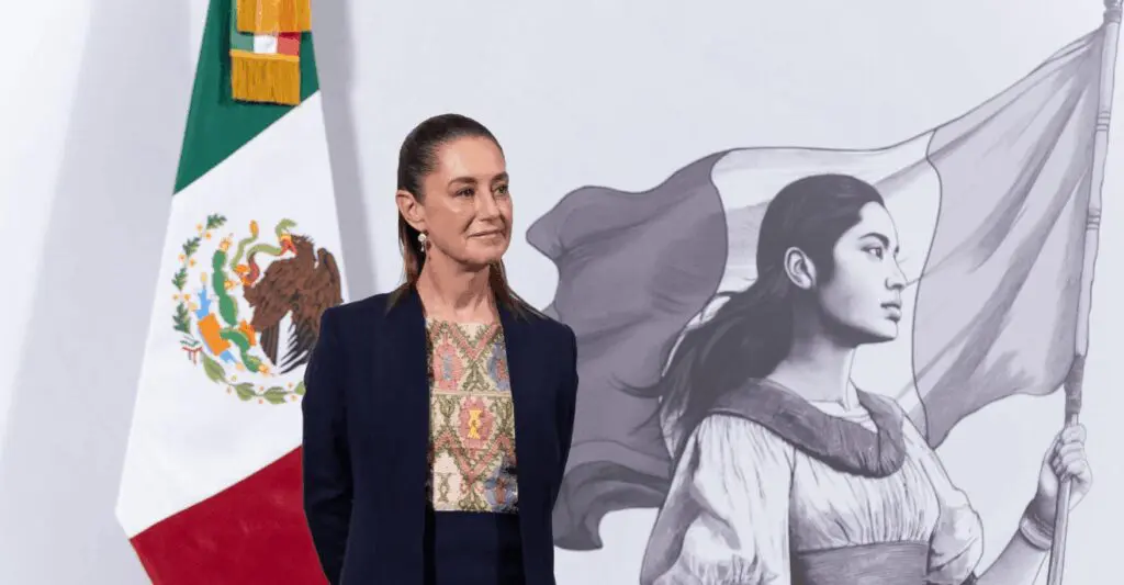 Woman in navy jacket beside flag mural