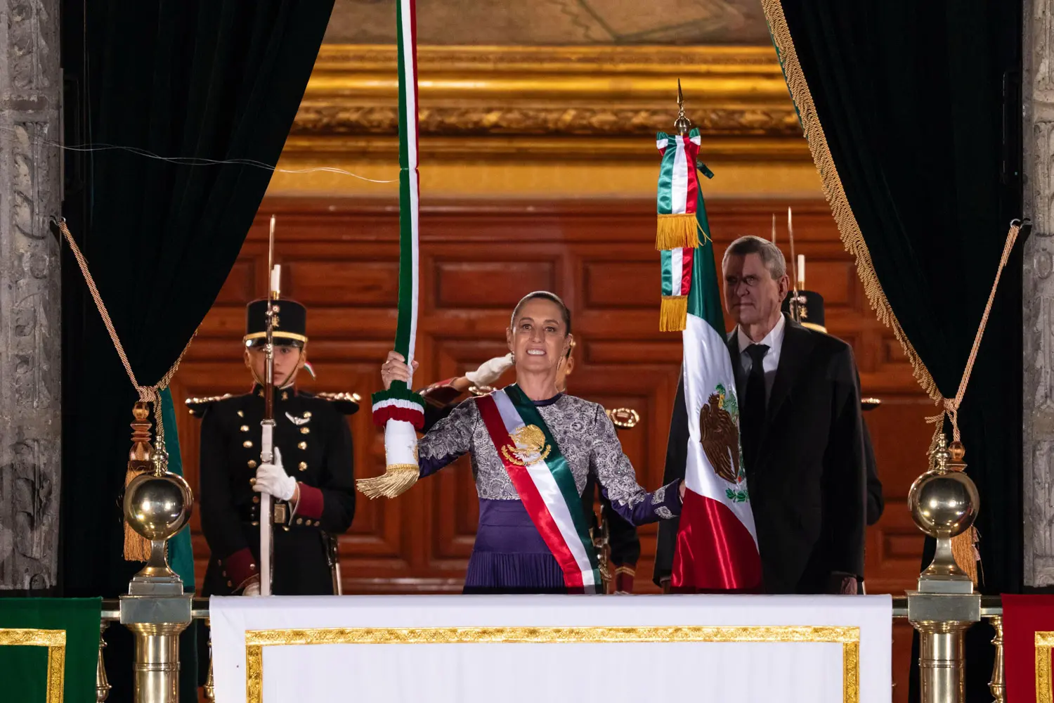 La presidenta Claudia Sheinbaum ondea la bandera nacional desde Palacio Nacional durante el Grito de Independencia.