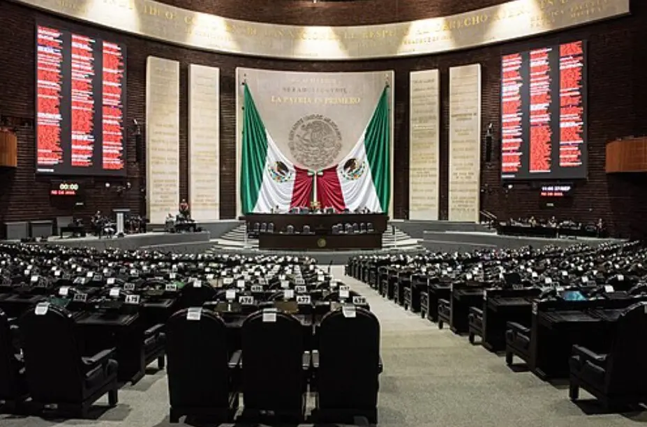 Empty Mexican legislative chamber with national flag