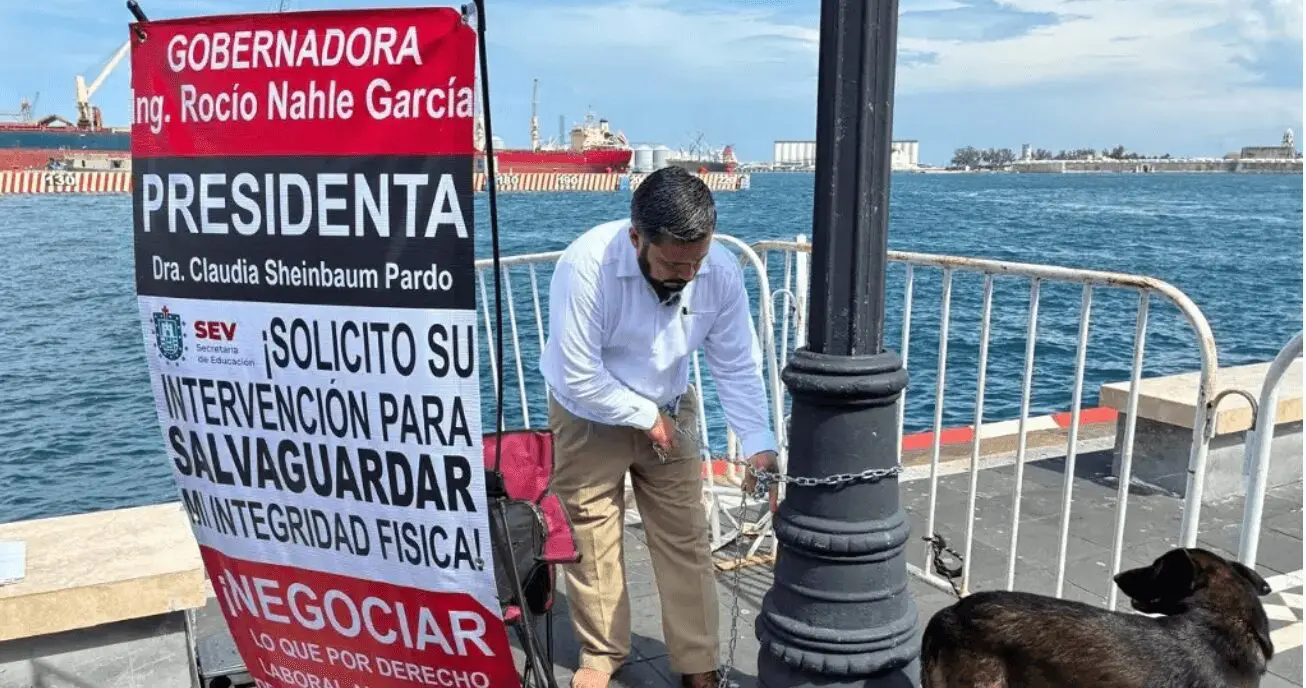 Maestro en Veracruz se encadenó en el malecón e inició huelga de hambre para exigir el pago de su seguro por invalidez.