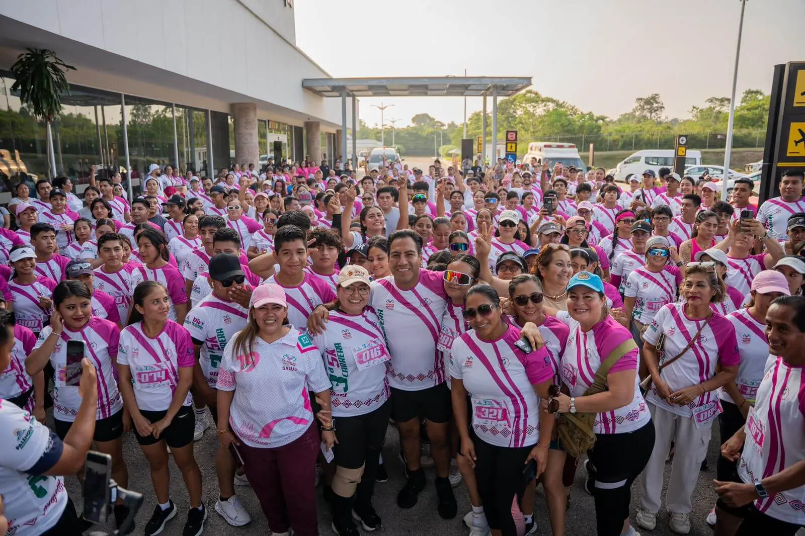 Large group wearing pink and white charity shirts