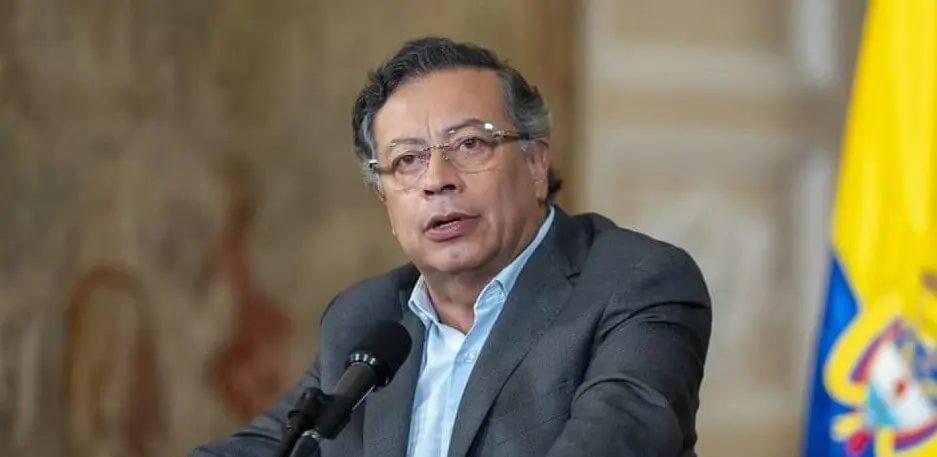 Man speaking at podium with yellow flag