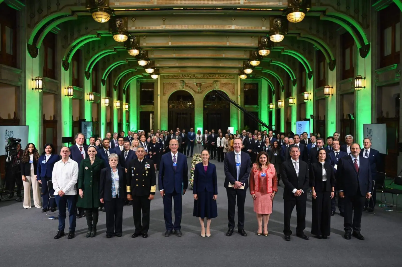 Formal group portrait in green-lit ornate hall
