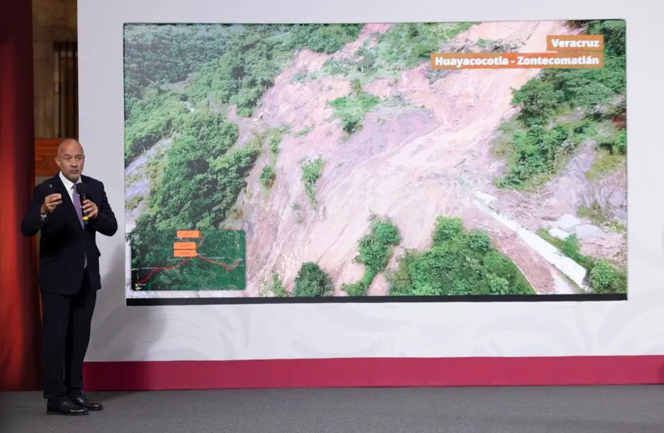 Presenter beside screen displaying Veracruz hillside landslide