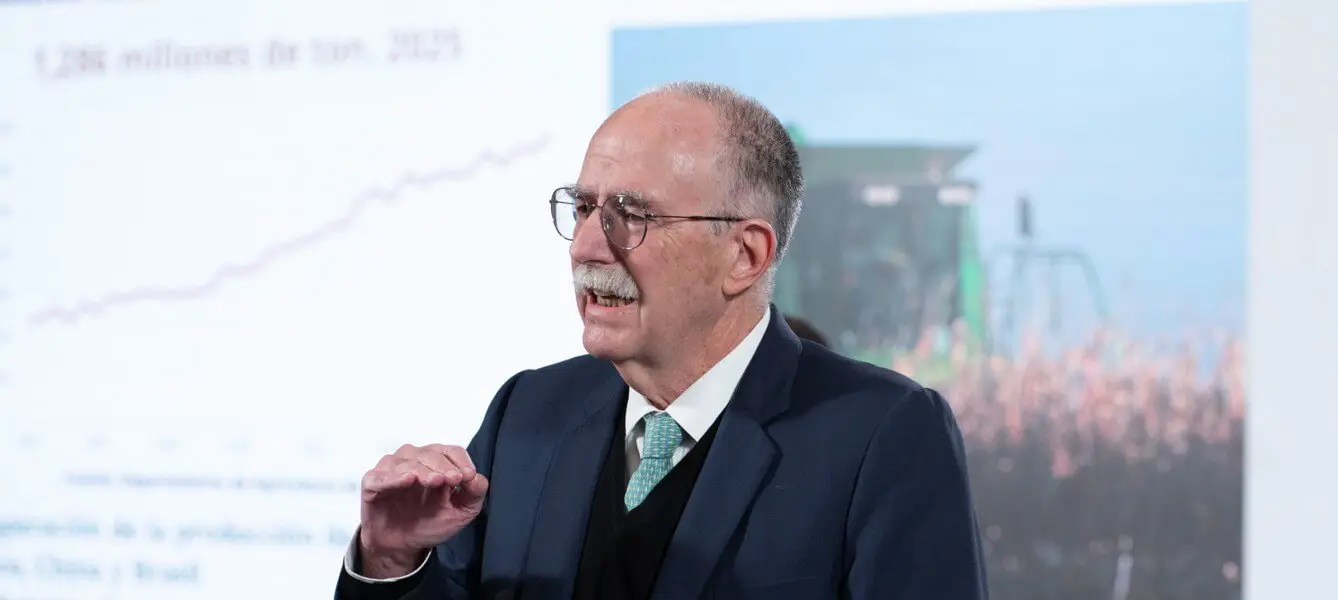 Man presenting agricultural data with combine backdrop