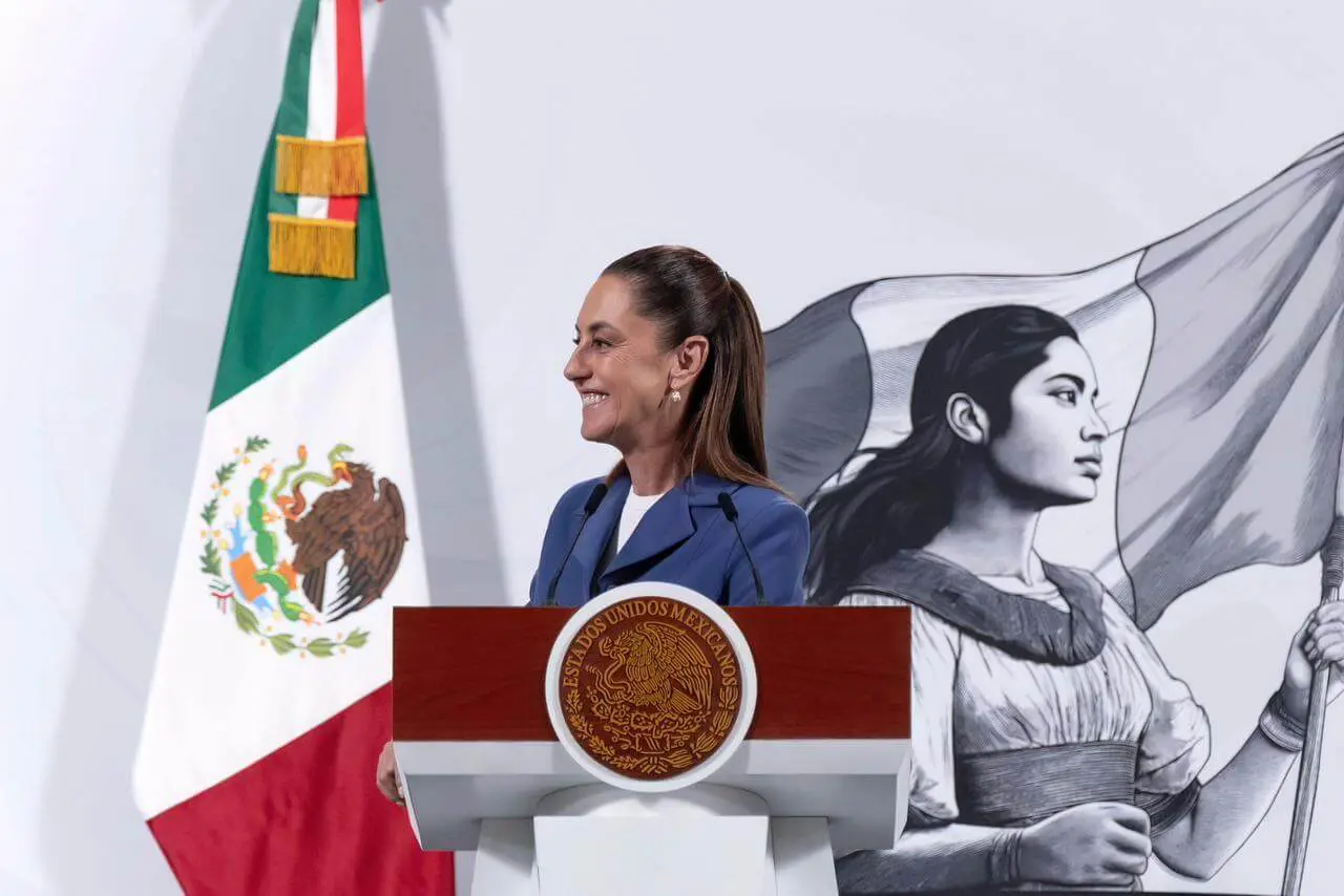 Smiling woman at podium with Mexican flag