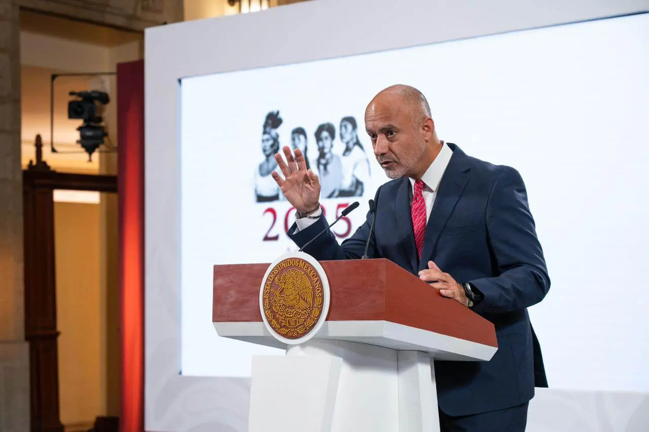 Bald man in suit speaking at podium